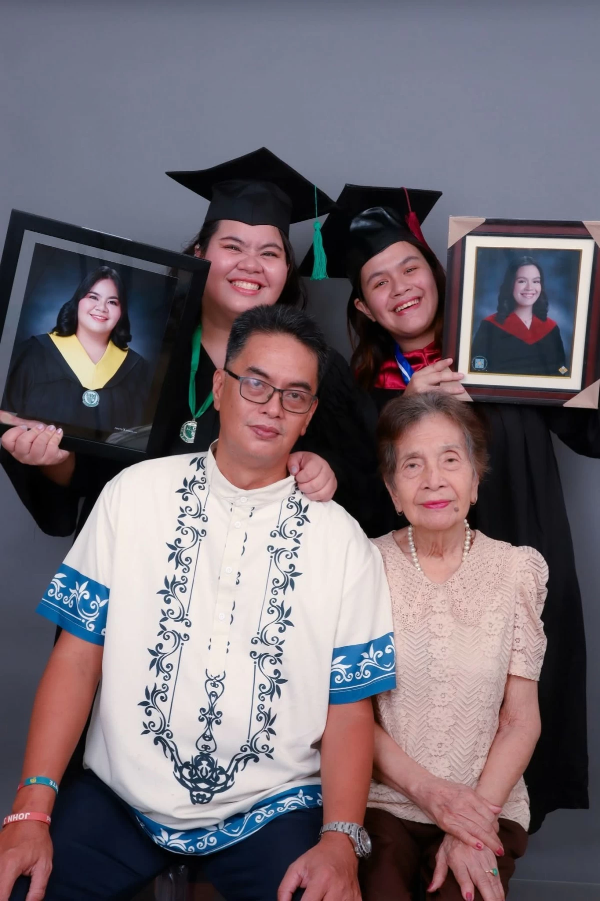 Rheanna (right) with her sister Rheinnea (left), their father Rhonnel (seated, left), and grandmother Librada (seated, right).