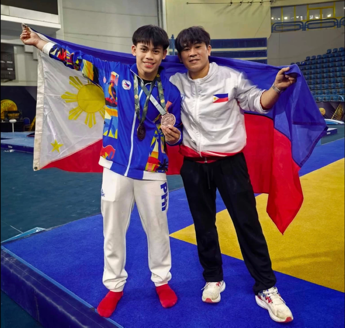 Eldrew Yulo, left, poses with coach Reyland Capellan. (GAP)
