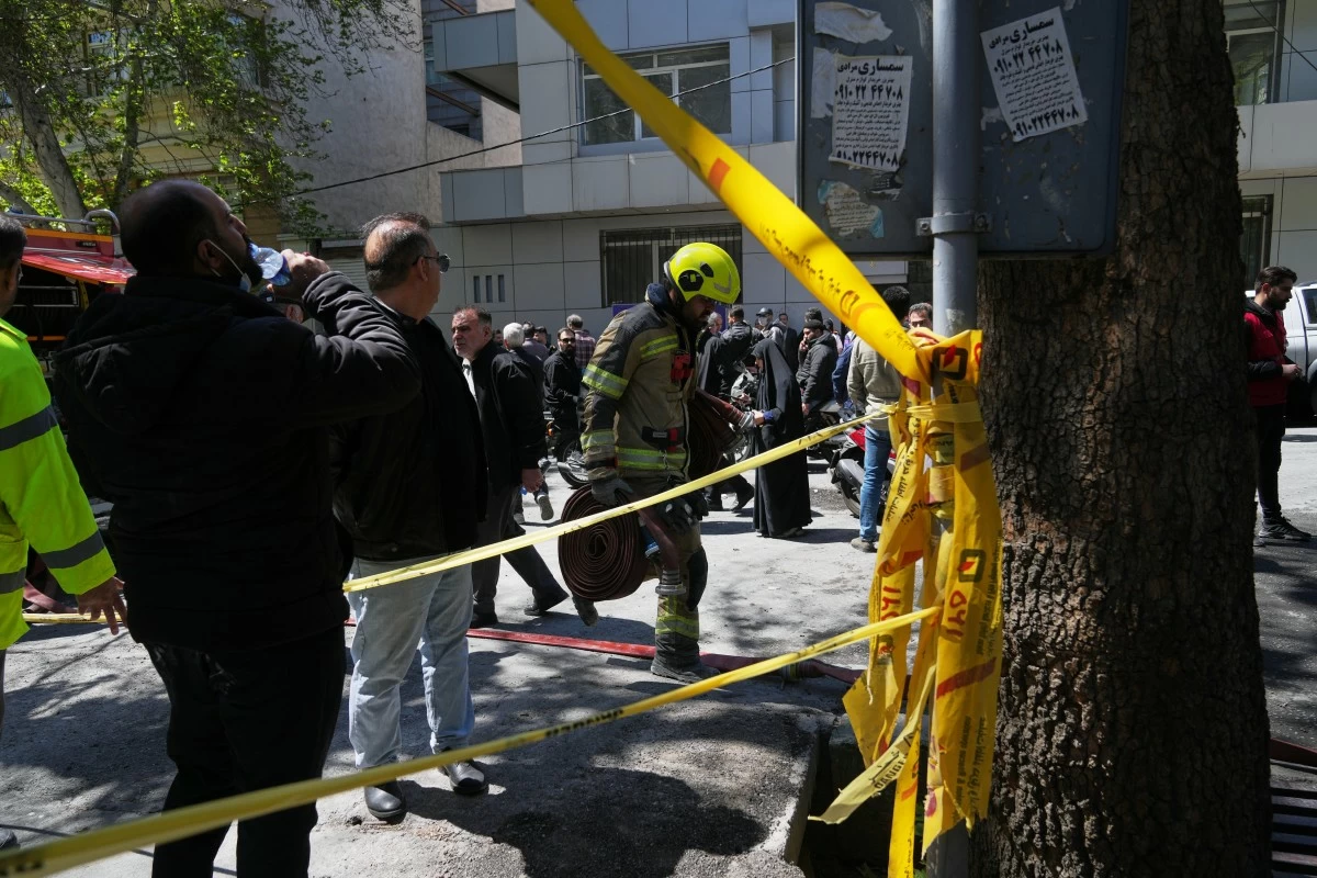 A first responder leaves the site of a strike that, according to a security official at the scene, destroyed half of the Khorasaniha Synagogue and nearby residential buildings in Tehran, Iran, Tuesday, April 7, 2026. (AP Photo/Francisco Seco)