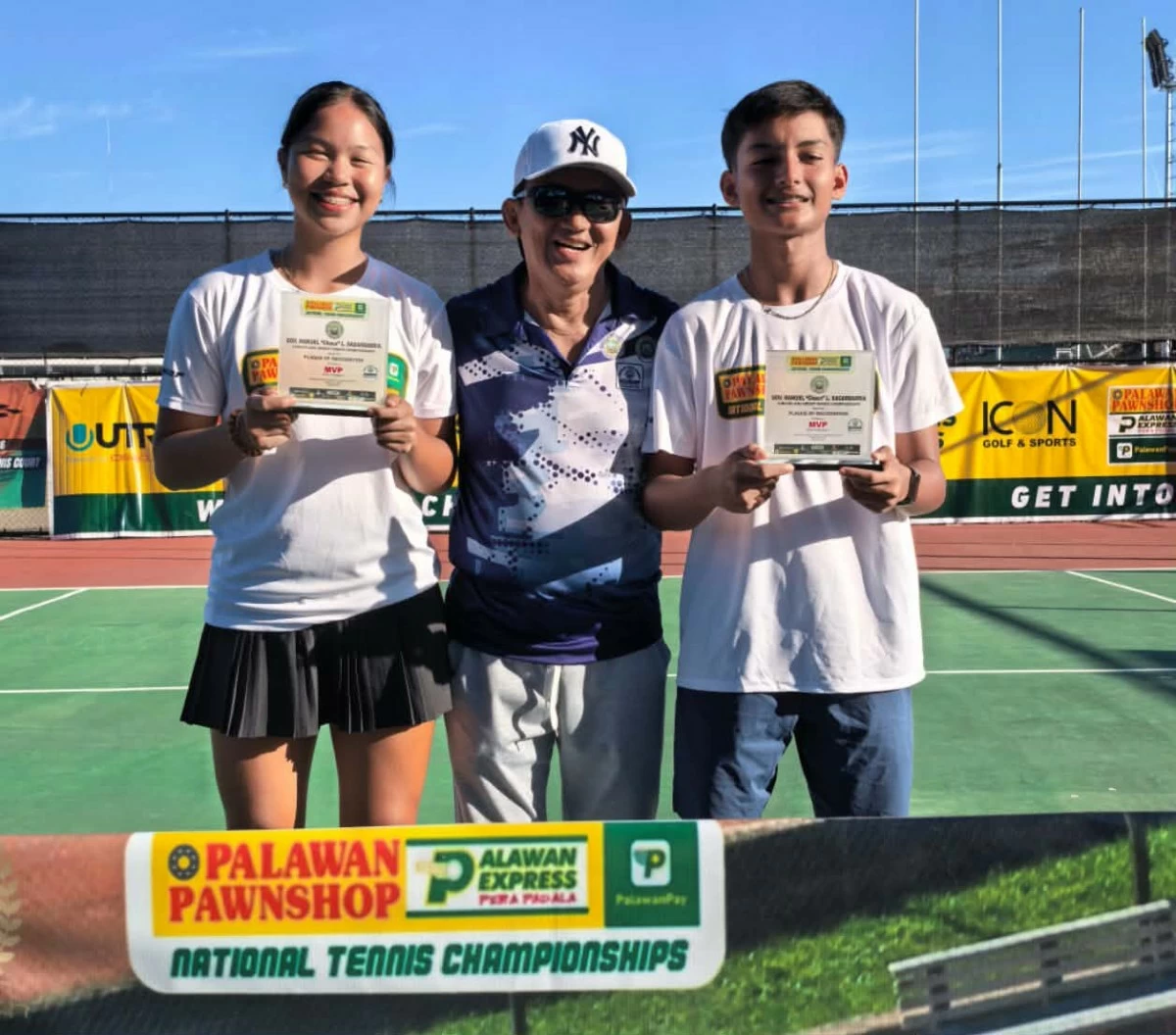 Matthew Morris, right, holds his trophy as he shares centerstage with Mitchellen Cruspero after a dominant performance in the Governor’s Cup. With them is NOSDEP official Allan Nocete.