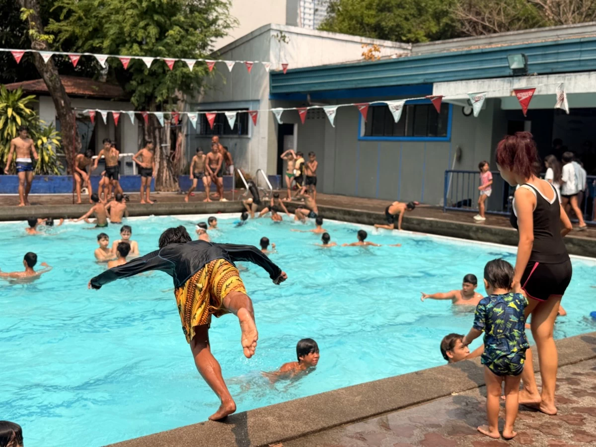 Swimmers dive and splash into the water at the Dapitan Sports Complex, one of six free public pools opened across Manila’s districts, turning peak summer heat into a communal cooling escape.