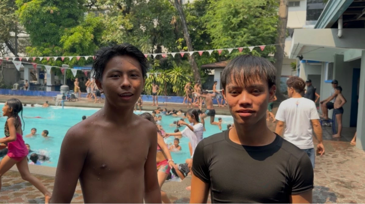 Geoff Aaron Rañoco, 16, and Angelo Prudencio, 17, both residents of Sampaloc, take a break after swimming at the Dapitan Sports Complex, saying the free pool access is “worth it” despite long queues.