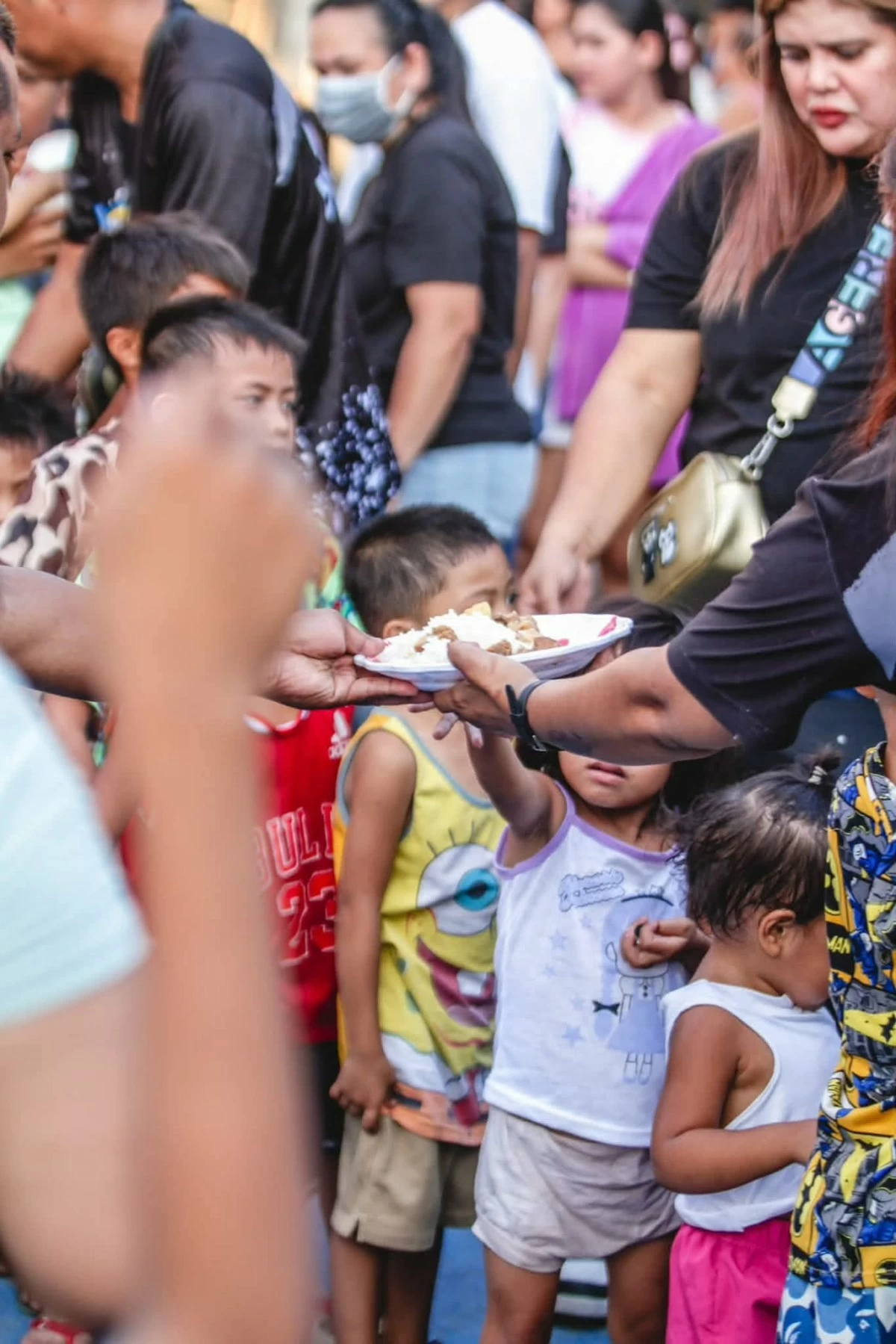 Residents, including children, line up during the return of the “One Cainta Pantry” feeding program, which provides free dinner to residents of Cainta, Rizal. (Photos from Mayor Kit Nieto)