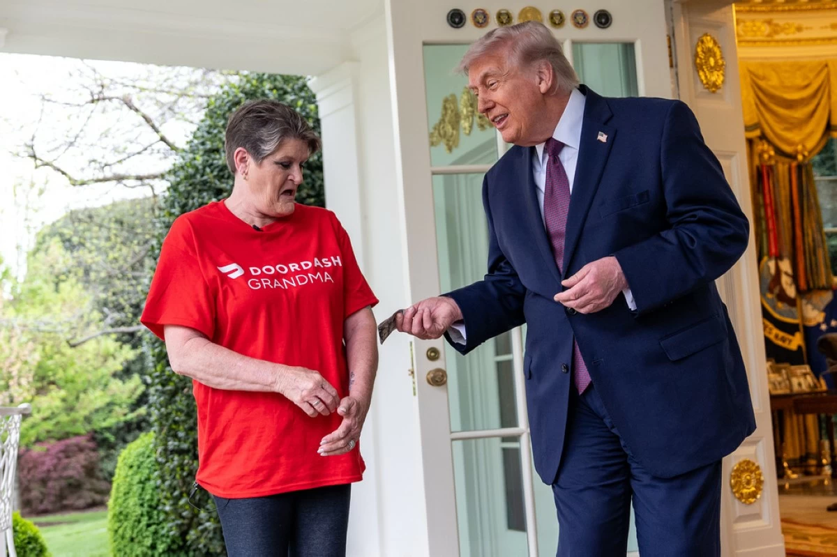 Sharon Simmons with DoorDash, gets a $100 tip after delivering McDonald's to President Donald Trump in the Oval Office of the White House, Monday, April 13, 2026, in Washington. (AP Photo/Alex Brandon)