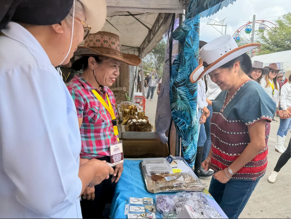 The First Lady and Vinny Marcos tour the exhibition booths during the 30th Rodeo Masbateño Festival. Mrs. Marcos took a close interest in the local crafts, asking vendors about their materials and earmarking several items to be featured in an upcoming exhibition for the ASEAN summit.