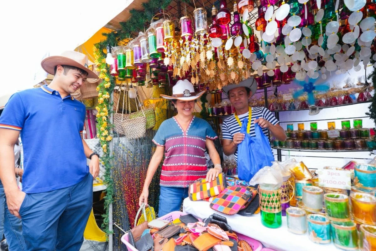 The First Lady and Vinny Marcos tour the exhibition booths during the 30th Rodeo Masbateño Festival. Mrs. Marcos took a close interest in the local crafts, asking vendors about their materials and earmarking several items to be featured in an upcoming exhibition for the ASEAN summit.