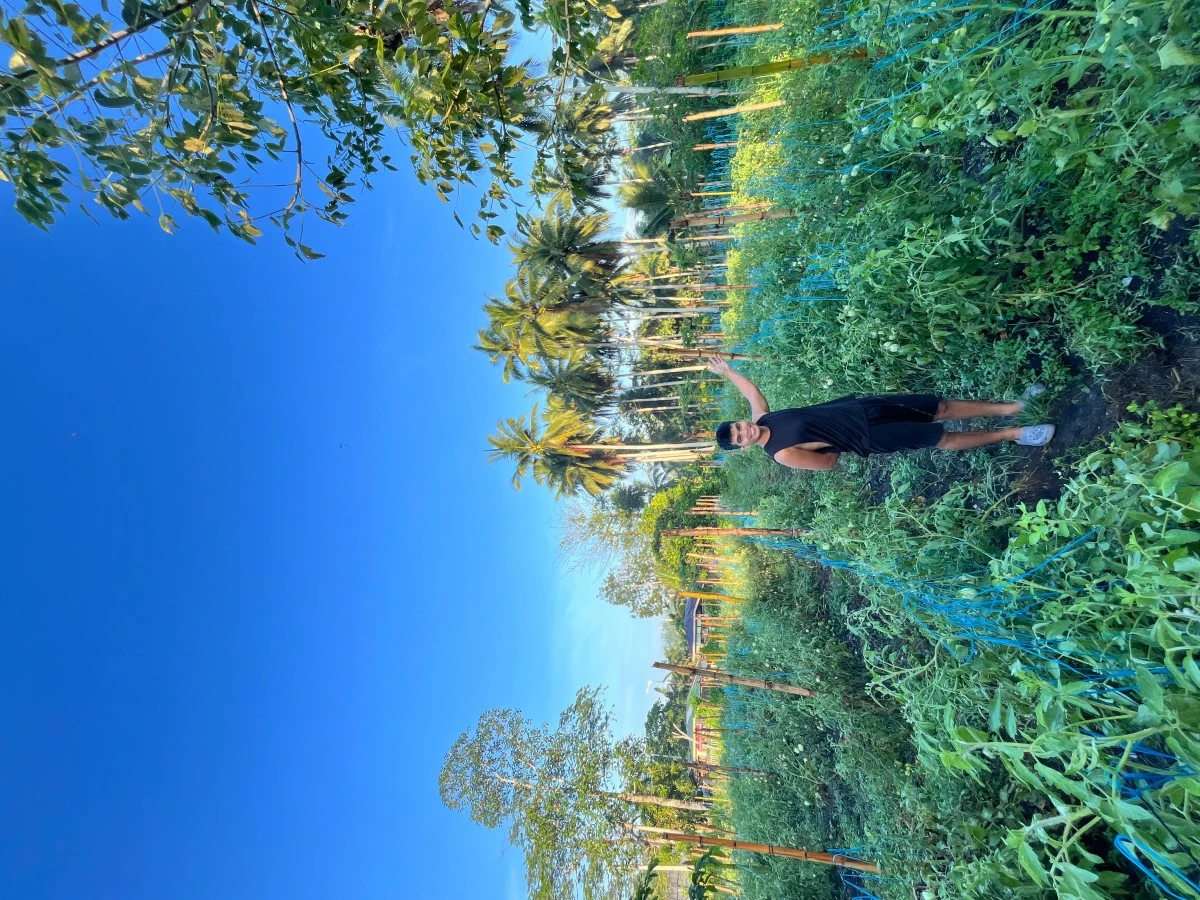 DEDICATED FARMER – Erhlan Cerdon, a firefighter and farmer, stands proudly at Hesed Farm with his growing operation behind him.