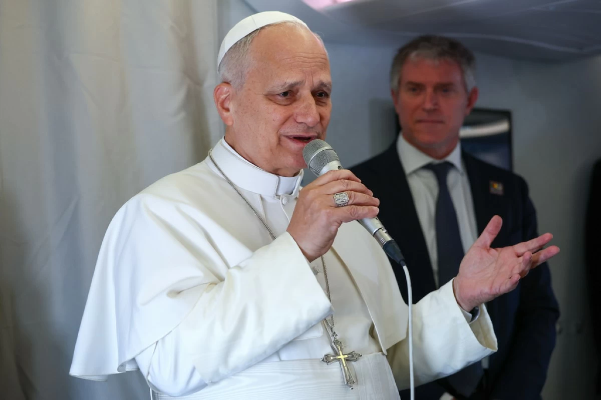 Pope Leo XIV speaks to journalists aboard his flight bound for Yaounde-Nsimalen International Airport, Cameroon, Wednesday, April 15, 2026, on the third day of an 11-day apostolic journey to Africa. (Guglielmo Mangiapane/Pool Photo via AP)