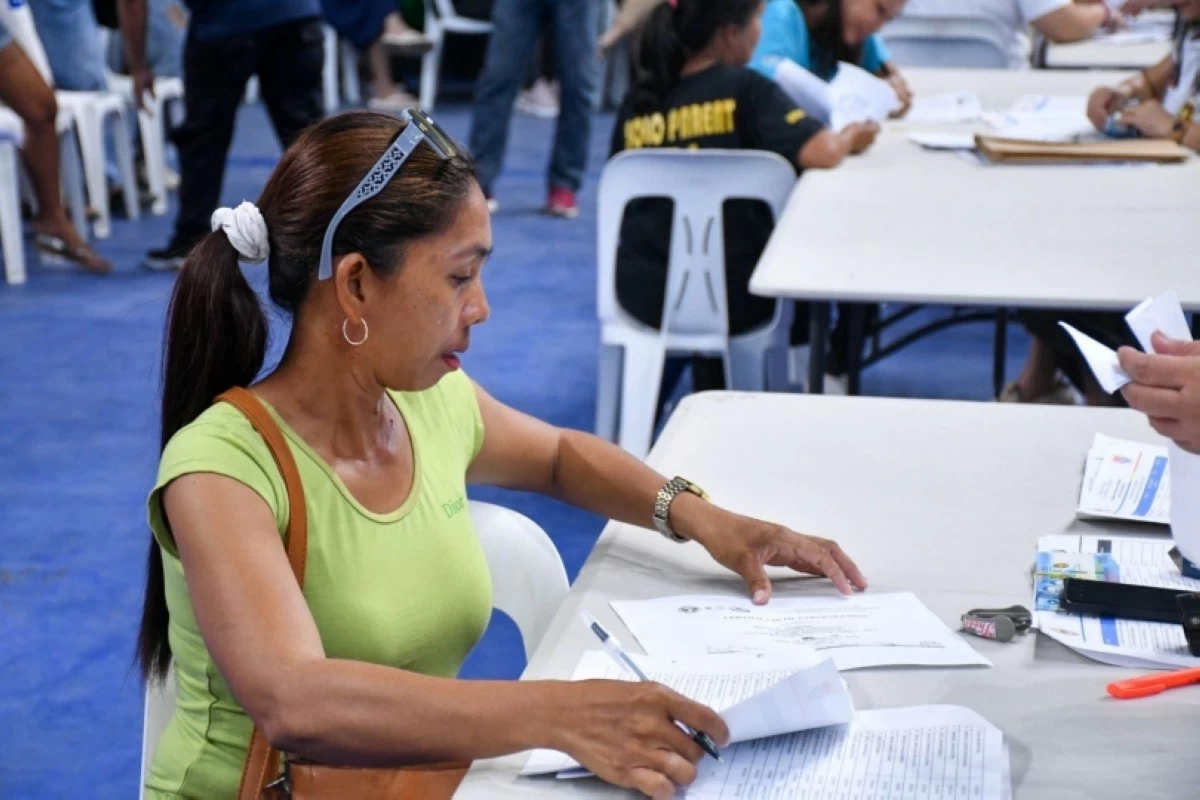 A solo parent getting her monthly cash assistance from the Muntinlupa City government (Photo from Muntinlupa PIO) 