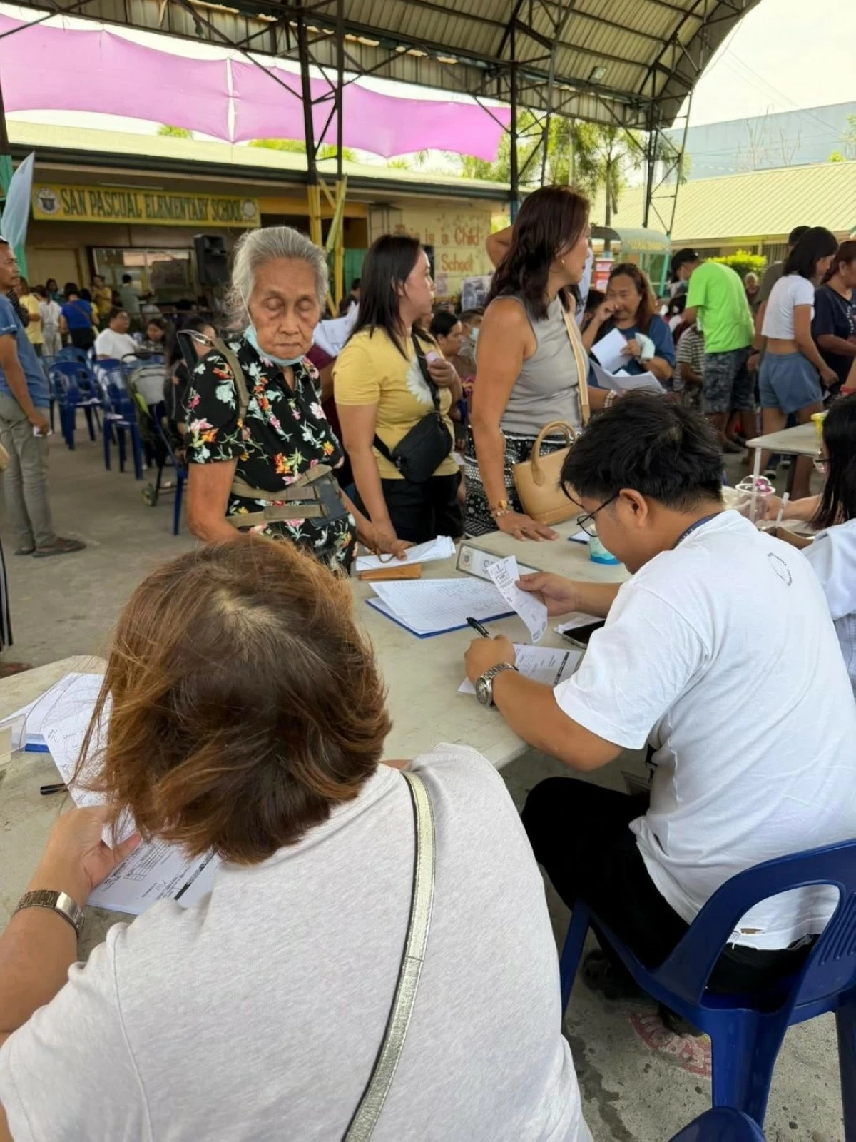 Residents from various villages in Obando, Bulacan, affected by smoke from the burning Navotas Sanitary Landfill, line up for free medical services during the Damayan sa Barangay mission organized by Damayan Filipino Movement Inc. on Wednesday, April 22, 2026. (Photos courtesy of Ronnie Navarro Fernando)