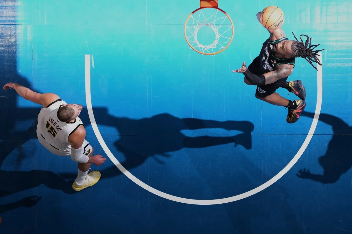 Minnesota Timberwolves guard Ayo Dosunmu (13) shoots as Denver Nuggets center Nikola Jokic (15) defends during the first half in Game 3 of a first-round NBA basketball playoff series, Thursday, April 23, 2026, in Minneapolis. (AP Photo/Abbie Parr)