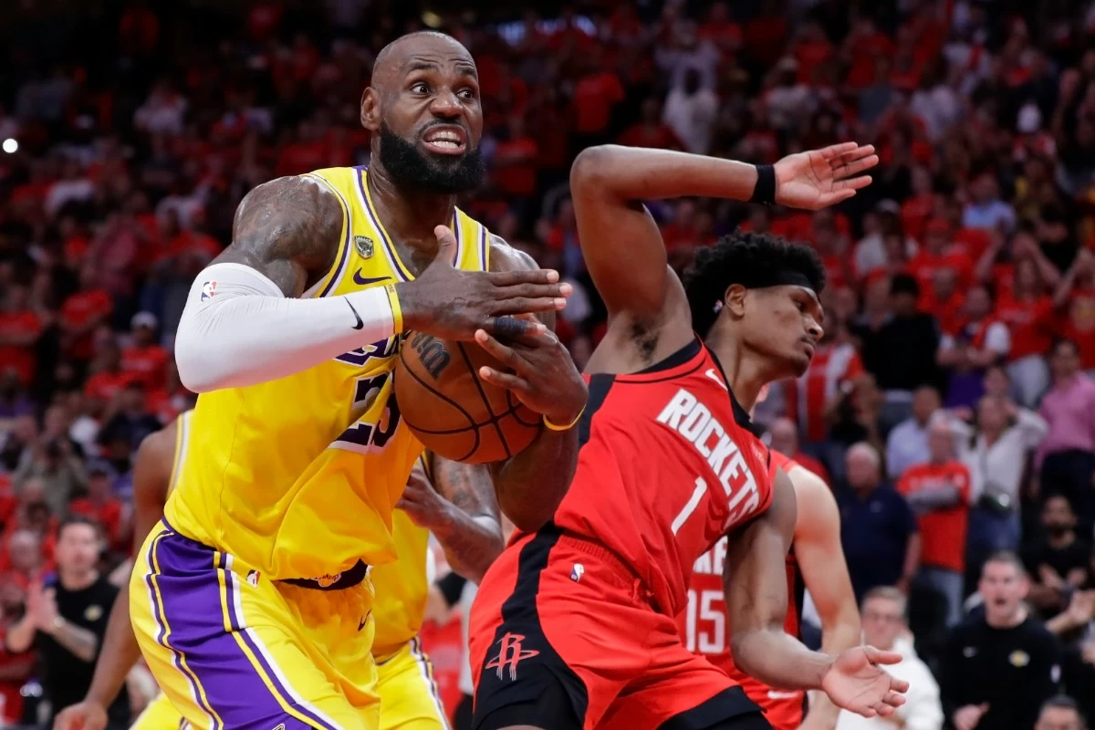 Los Angeles Lakers forward LeBron James, left, immediately signals for a timeout after winning a rebound from Houston Rockets guard Amen Thompson (1) during the second half of Game 3 in a first-round NBA playoffs basketball series Friday April 24, 2026, in Houston. (AP Photo/Michael Wyke)