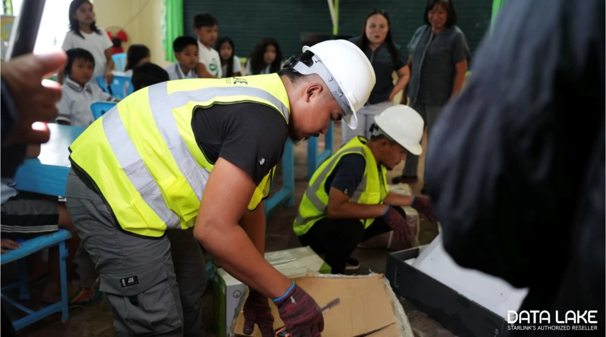 Students and teachers observe as installers set up the Starlink kit at New Rizal Elementary School, Zamboanga del Norte.