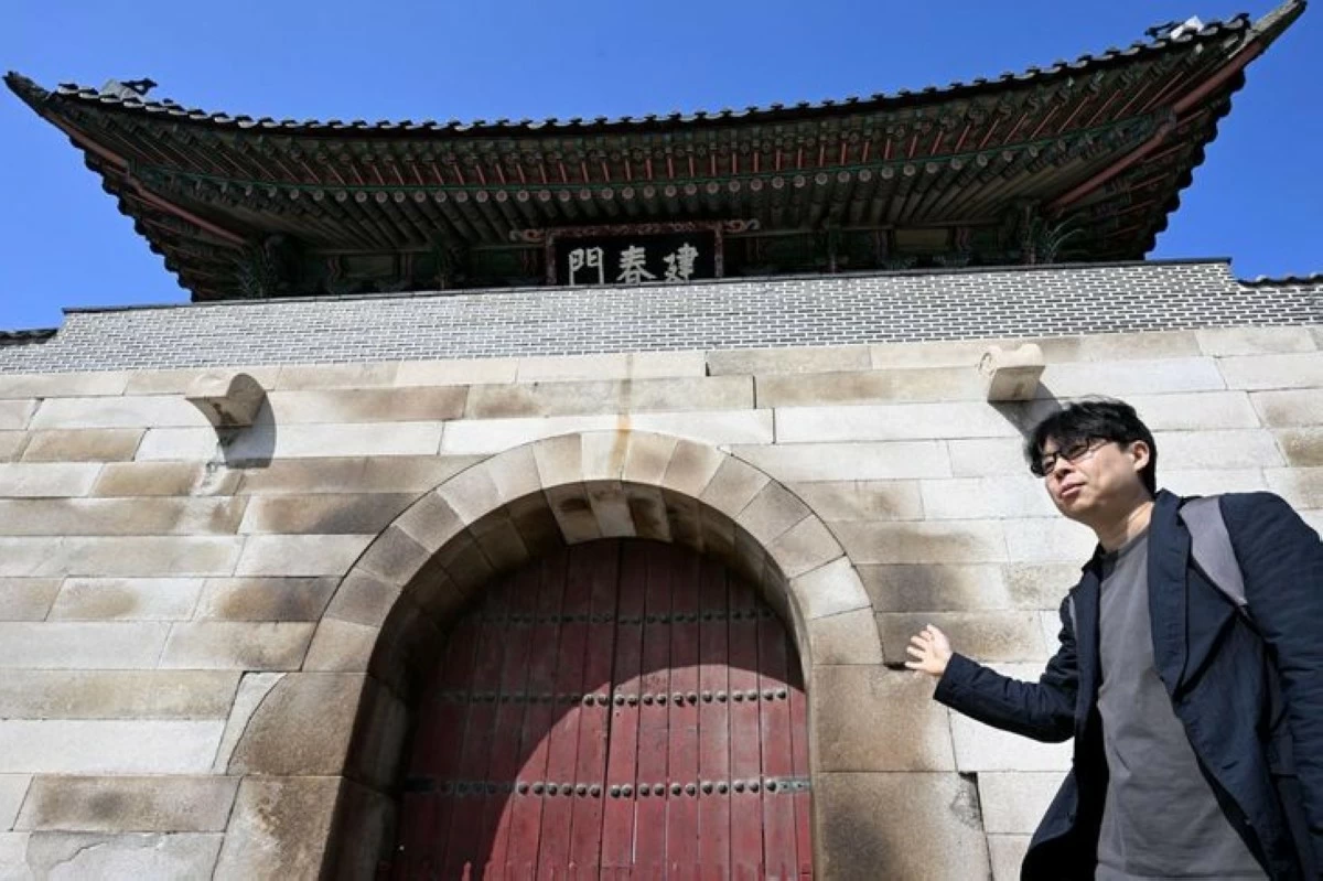 Chun Kyung-hwan speaks about Bukchon’s topographical character in front of Geonchunmun, the east gate of Gyeongbok Palace, on March 31. (Photo: The Korea Times, Park Ji-yeon)