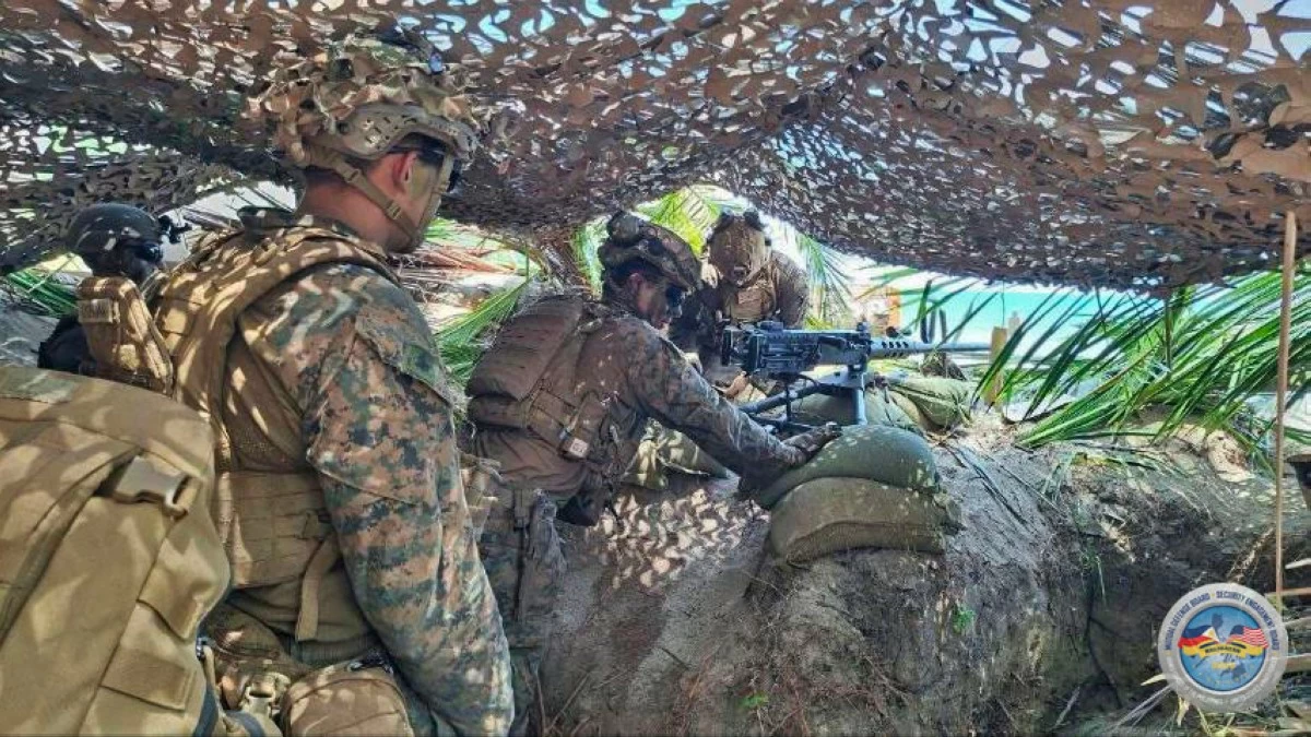 United States forces coordinate heavy machine gun suppression from a fortified position under a camouflage net during the Counter-Landing Live Fire Exercise at Apurawan Beach in Aborlan, Palawan on April 27, 2026 as part of Exercise Balikatan. (Photo by 3rd Marine Brigade, Philippine Marine Corps)