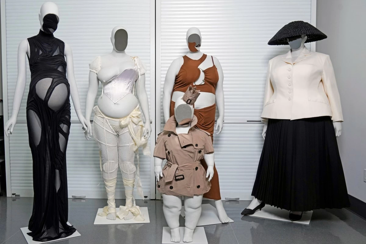 A Di Petsa dress by designer Dimitra Petsa appears on a pregnant mannequin, from left, an ensemble by Michaela Stark on a mannequin in Stark's image, a Burberry ensemble by Christopher Bailey on a mannequin image of Sinéad Burke, foreground, an ensemble by designer Karoline Vitto, on a mannequin model of Charlie Reynolds, and an outfit by designer Maria Grazia Chiuri for the House of Dior on a mannequin model of Yseult, are displayed in a room at the Metropolitan Museum of Art during preparations for the Met Gala exhibit 