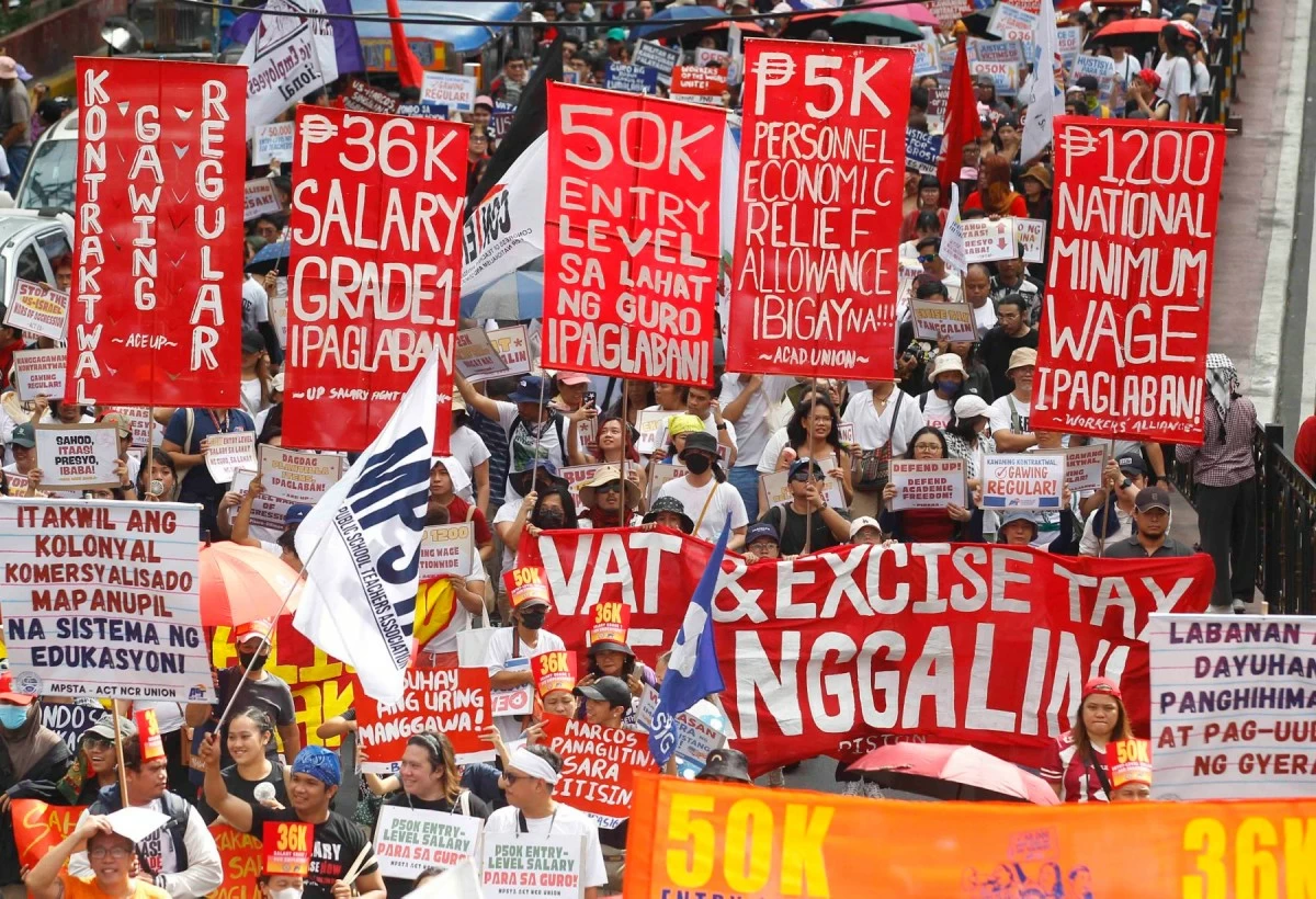 Rallyists carry placards and flags during the Labor Day protest in Manila, voicing calls for stronger labor protections amid rising economic pressures.