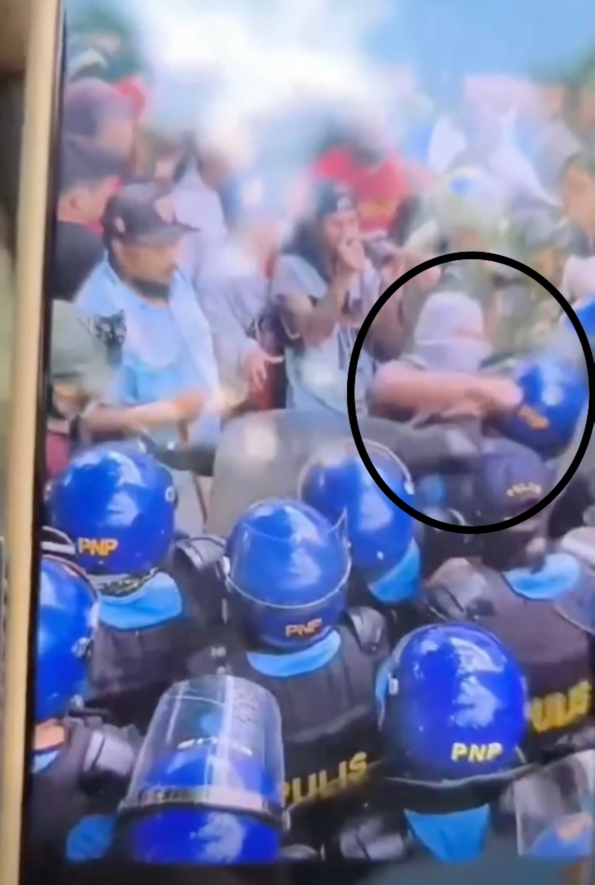 A protester clad in gray short and a face cover takes a swing at a police officer deployed for civil disturbance management (CDM) allegedly during a Labor Day protest on May 1, 2026. The Philippine National Police (PNP) is verifying where the incident took place and the identity of the protester. (Master Raray Cruz / Facebook)