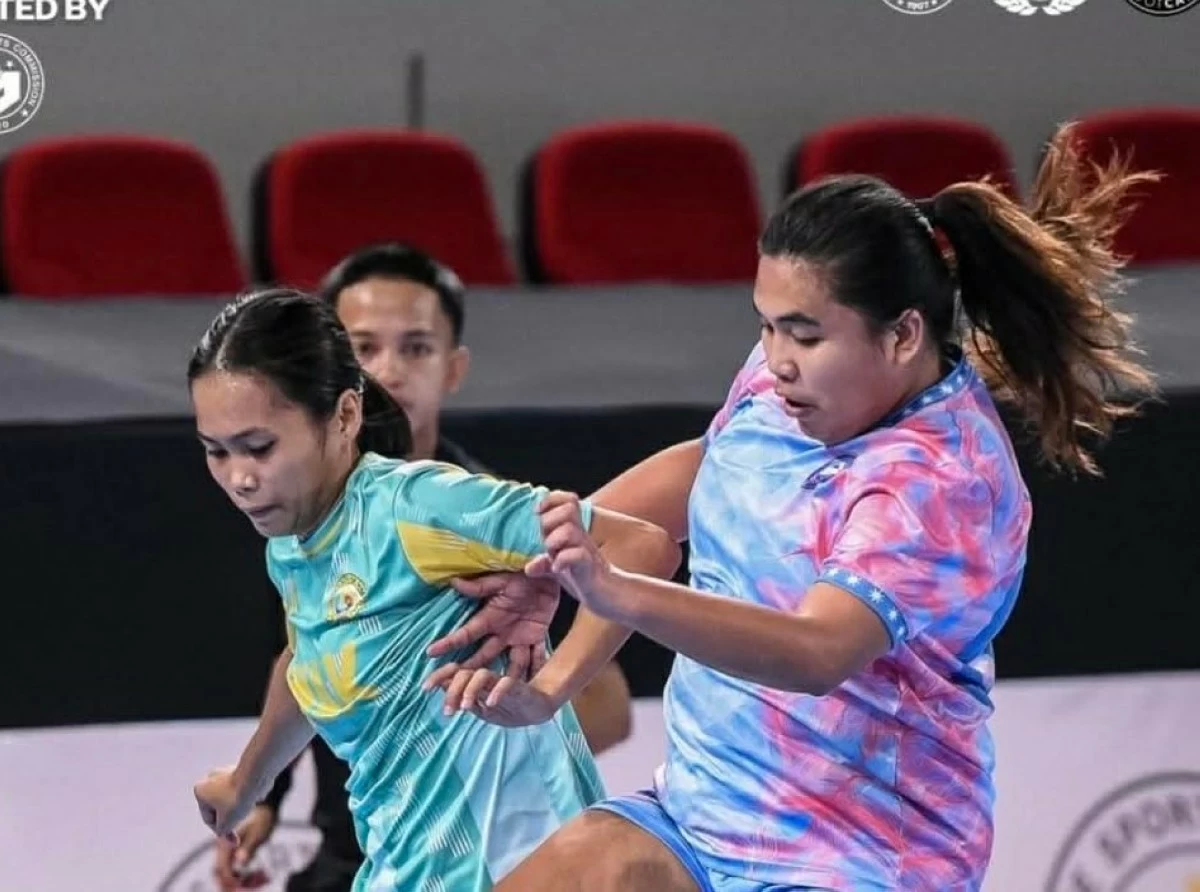 Princess Caparida of the Azkals Development Club (right) attacks past UMak's Princess Beth Caparida. 
