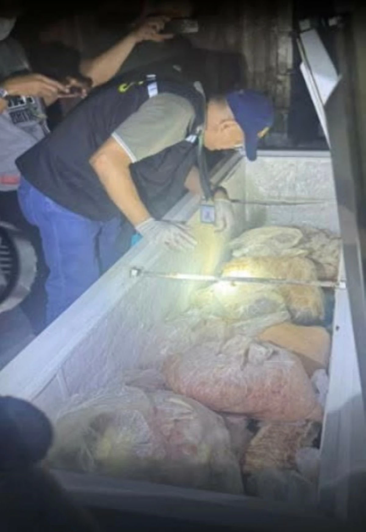A policeman inspects the double dead meat that the NCRPO confiscated during a raid in Marikina City. Around 20 tons of double dead meat were confiscated while 12 people were arrested. (photo: NCRPO)