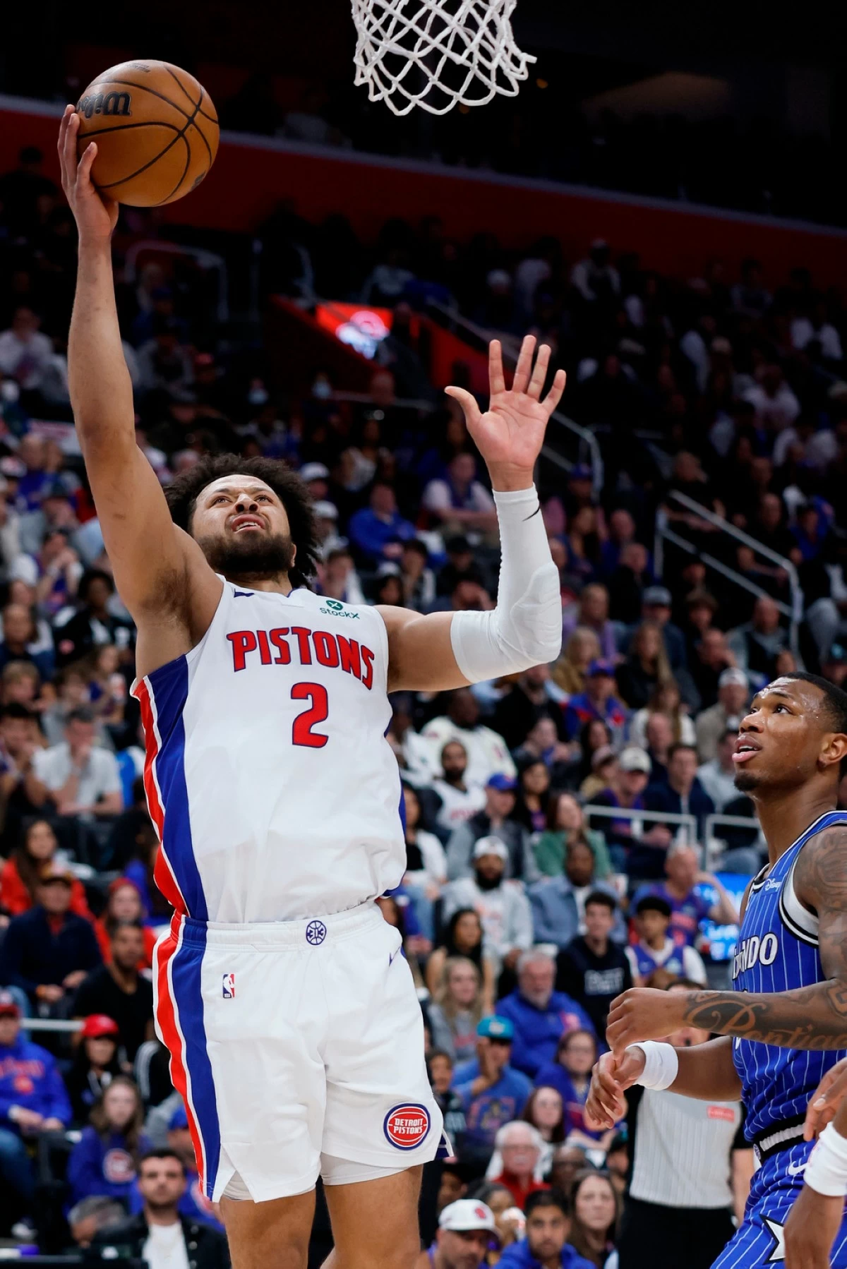 Detroit Pistons guard Cade Cunningham (2) goes to the basket past Orlando Magic forward Jamal Cain, right, during the first half in Game 7 of a first-round NBA basketball playoffs series Sunday, May 3, 2026, in Detroit. (AP Photo/Duane Burleson)