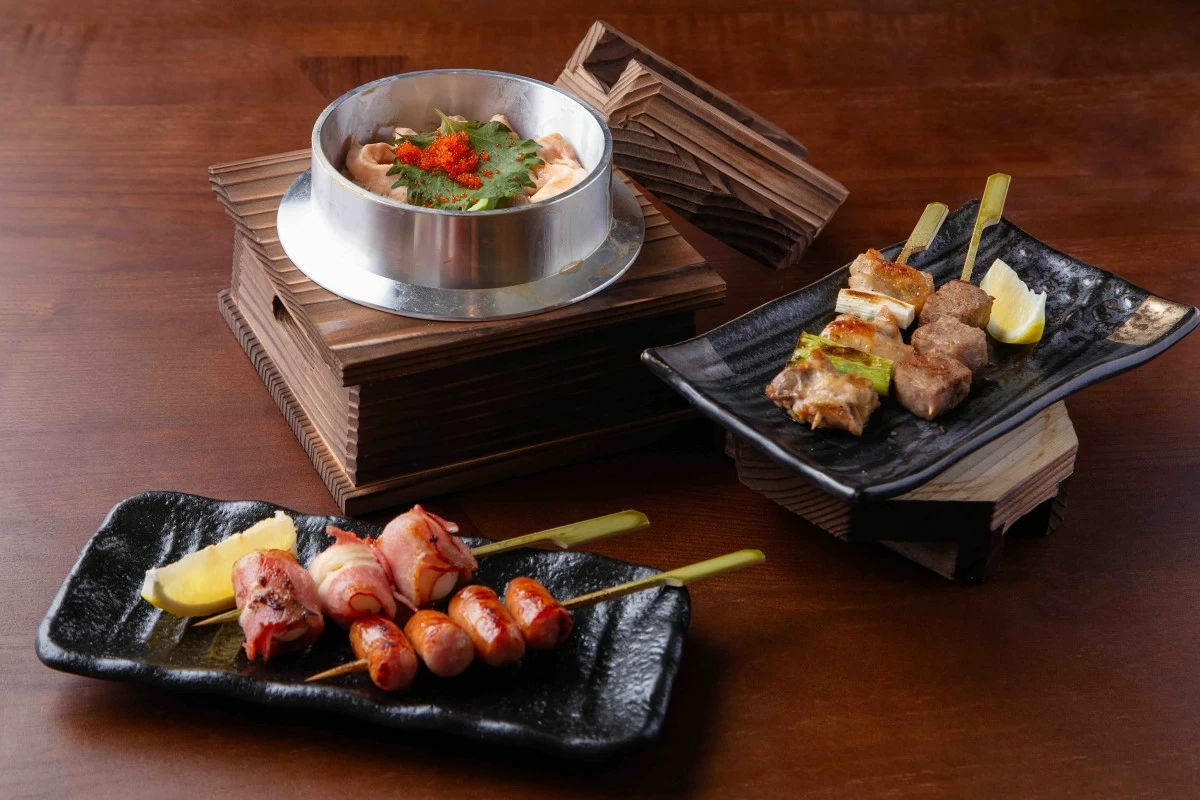 Shake kamameshi, a salmon and ikura rice casserole, delivers a rich, savory base layered with seafood flavor; and a Yakitori selection of negima, gyukushiyaki, uzura bacon yaki, and arabiki sausage showcases a mix of classic grilled bites. (Photo: Ogawa)