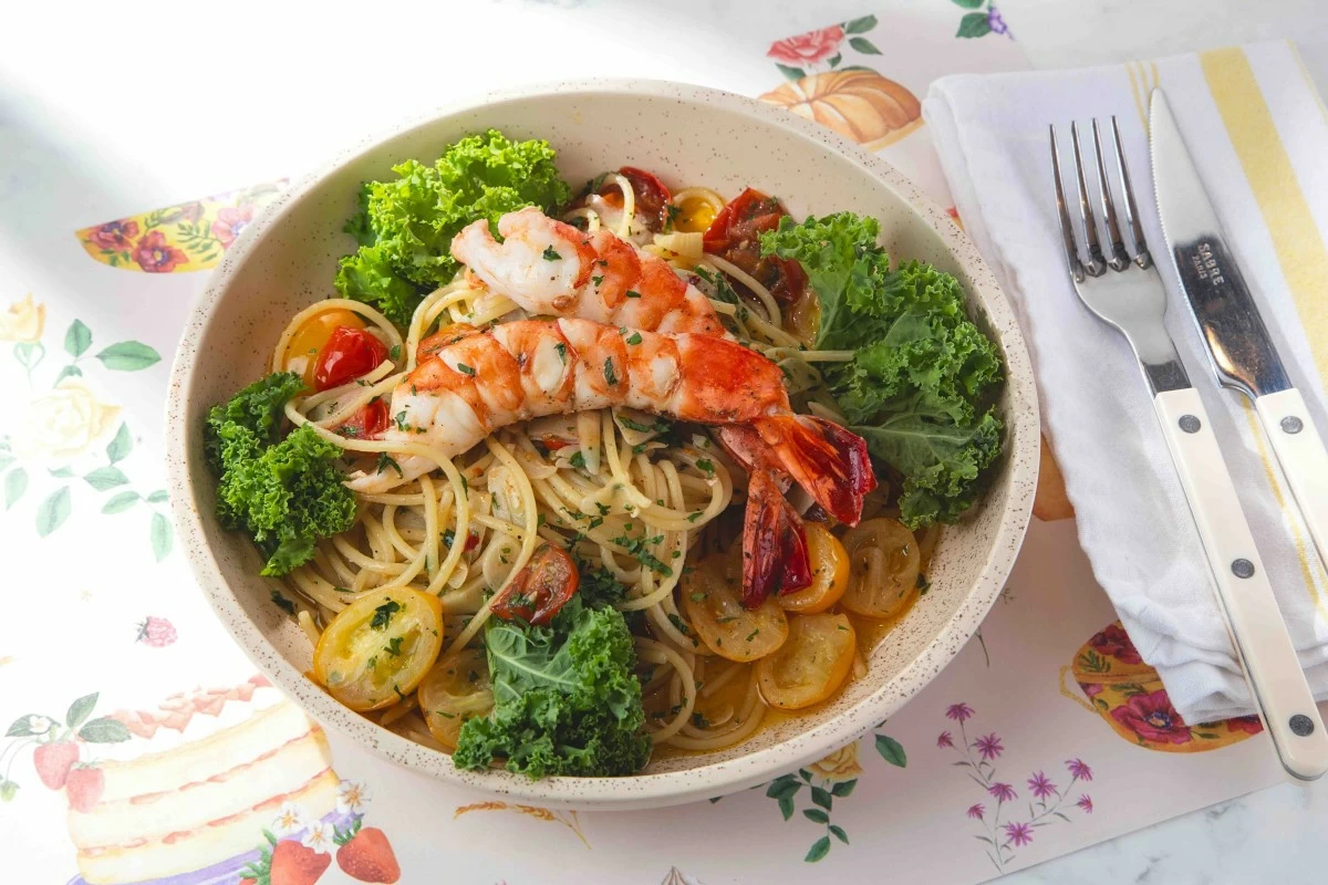 GARLIC PASTA Aglio olio with garlic, kale, cherry tomatoes, olive oil, and added shrimp tossed with spaghetti, a simple dish built on clean flavors.(Photo: Flour Pot Bistro and Bakery)