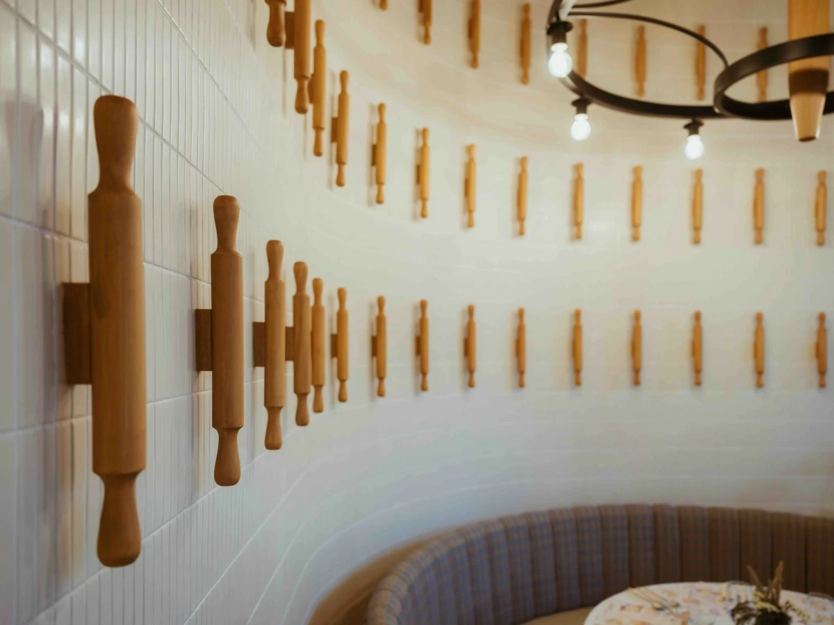 PIN WALL Repurposed rolling pins line the walls, adding texture and a subtle reference to baking throughout the interior. (Photo: Jay Jallorina)