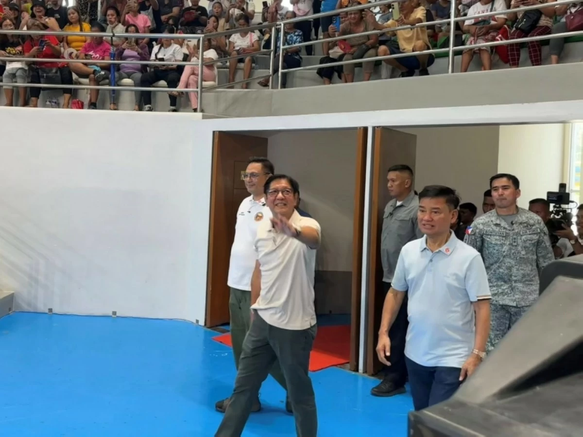 President Ferdinand Marcos Jr. waves to the crowd upon arriving at the Muntinlupa Sports Center with Muntinlupa Mayor Ruffy Biazon and Rep. Jaime Fresnedi for the distribution of rice and financial assistance on May 6 (Photo from  Muntinlupa PIO) 