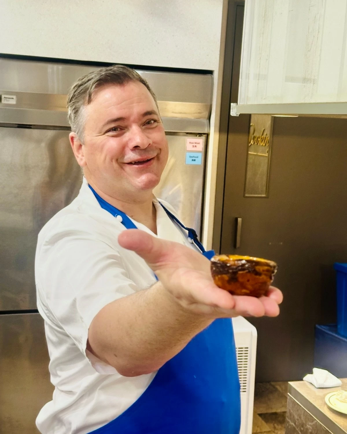 Grégoire Michaud of Bakehouse holding a freshly baked egg tart