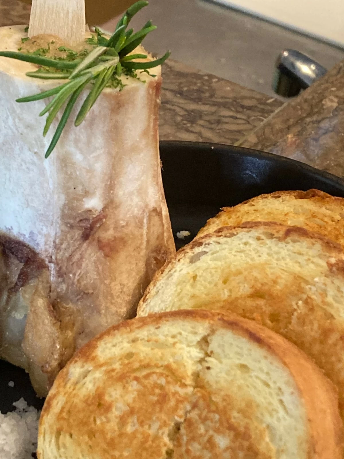 TARTAR DE BUEY Australian beef tenderloin, capers, shallots, roasted bone marrow, and toasted brioche