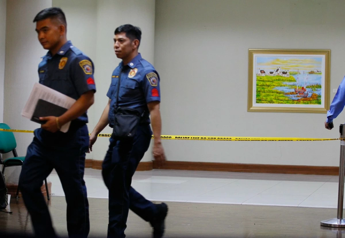 Personnel of the Philippine National Police walk past a police cordon leading to the site of the shooting inside the Senate of the Philippines in Pasay City on May 14, 2026. (Photo by Mark Balmores)