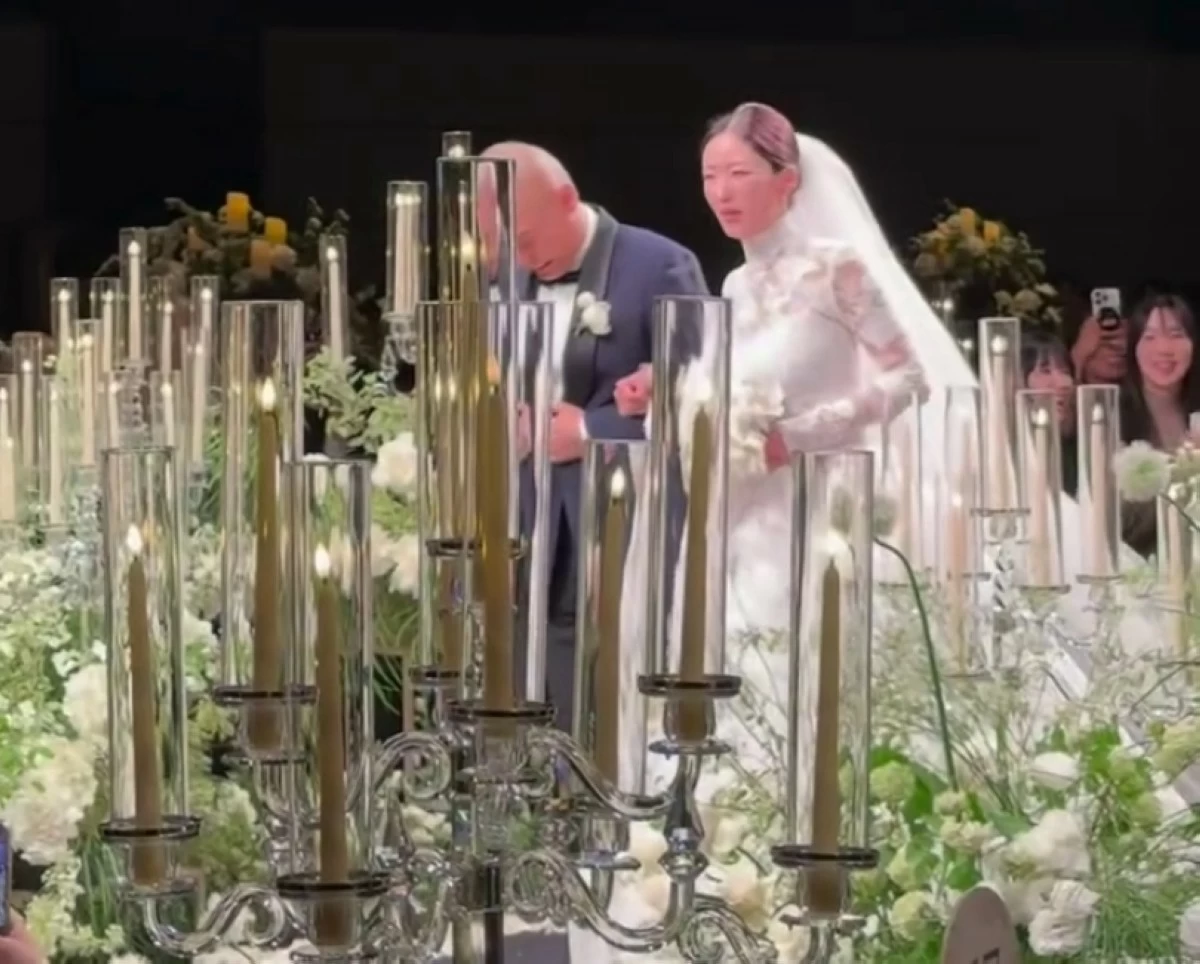 Apink's Bomi (right) and music producer Rado at their wedding on May 16 in Seoul (Screenshot from MakeupHyohyo's video on Instagram) 