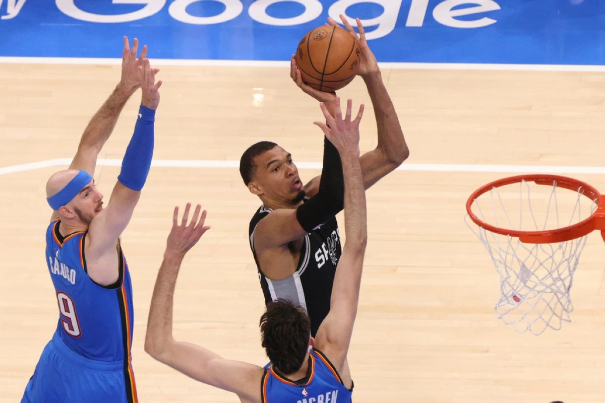 San Antonio Spurs forward Victor Wembanyama (1) shoots against Oklahoma City Thunder guard Alex Caruso (9) and center Chet Holmgren during the second half of Game 1 in a third-round NBA basketball playoffs series Monday, May 18, 2026, in Oklahoma City. (AP Photo/Nate Billings)