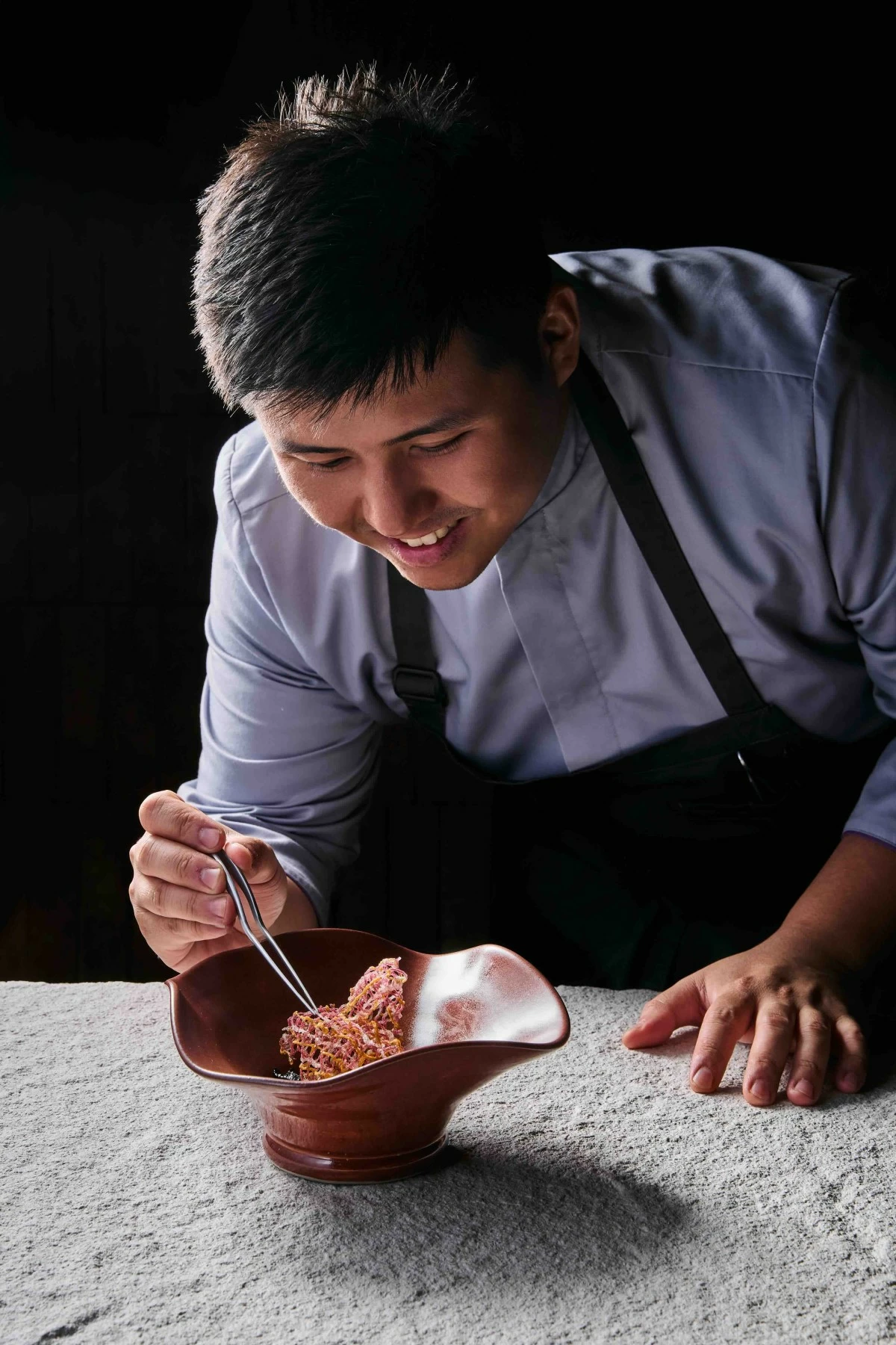 PLATED PRECISION Chef Kevin Uy prepares 'Amazon,' a pork dish paired with palm heart and banana as part of the tasting menu at Flow in Makati. (Photo: Fern Dy)