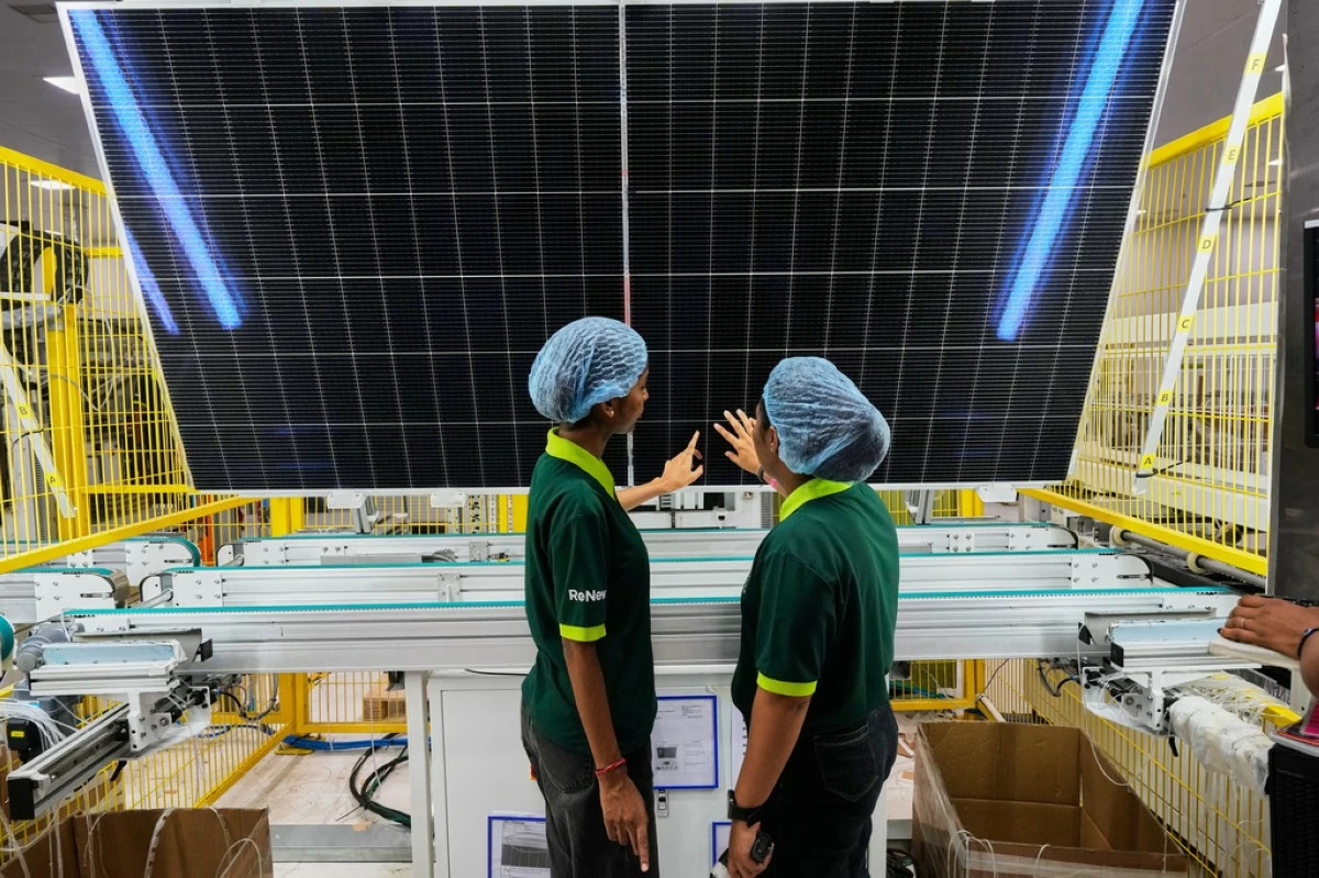 Workers check the quality of a solar panel at the production line up at the ReNew solar panels manufacturing plant on the outskirts of Jaipur, India, Aug. 21, 2025. (AP Photo/Manish Swarup)