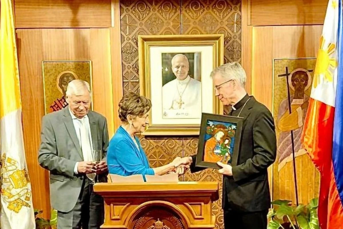 Archbishop Charles Brown III, Apostolic Nuncio and Dean of the Diplomatic Corps, presents Ambassador Răduţa Dana Matache with a framed Mother and Child image as a farewell token, joined by her spouse Constantine Matache. (Photos: Manila Bulletin)