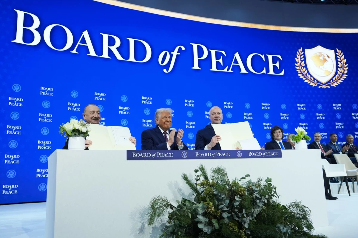 FILE - President Donald Trump, center, applauds as Ilham Aliyev, President of Azerbaijan, left, and Bulgaria's Prime Minister Rossen Jeliazkov, right, hold up their signed Board of Peace charter during the Annual Meeting of the World Economic Forum in Davos, Switzerland, Jan. 22, 2026. (AP Photo/Evan Vucci, File)