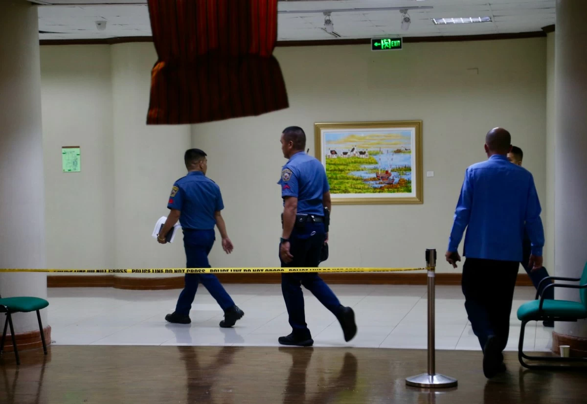 Personnel of the Philippine National Police walk past a police cordon leading to the site of the shooting inside the Senate of the Philippines in Pasay City on May 14, 2026. (Mark Balmores)