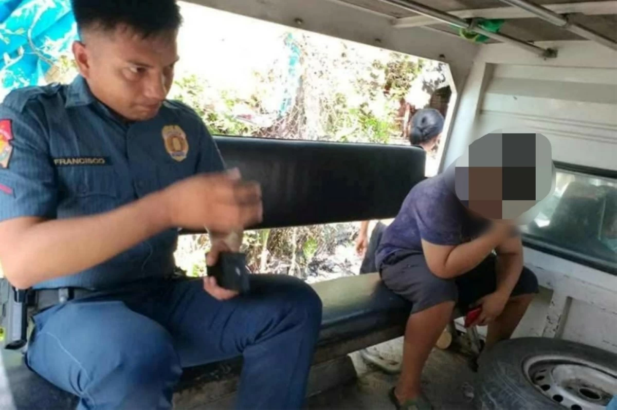 A Taguig police officer with the arrested suspect in the child abuse incident (Photo from Taguig police / SPD) 