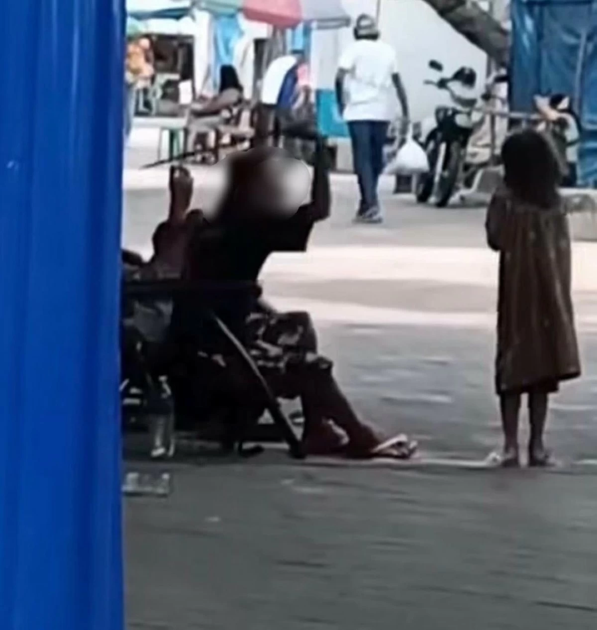 
A screengrab from a viral video shows a man holding a stick and hitting a child at the public plaza in Bacolod City. (Mayor Greg Gasataya FB)
