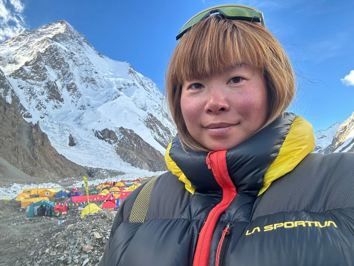 NAOKO Watanabe, a Guinness World Record holder as the first woman to scale the world's second highest mountain K2 three times, poses for a selfie near K2, back, with its summit at 8,611 meters above sea level, when she was at a base camp in Pakistan, July 12, 2024, before scaling K2 on July 28. (Naoko Watanabe via AP)
