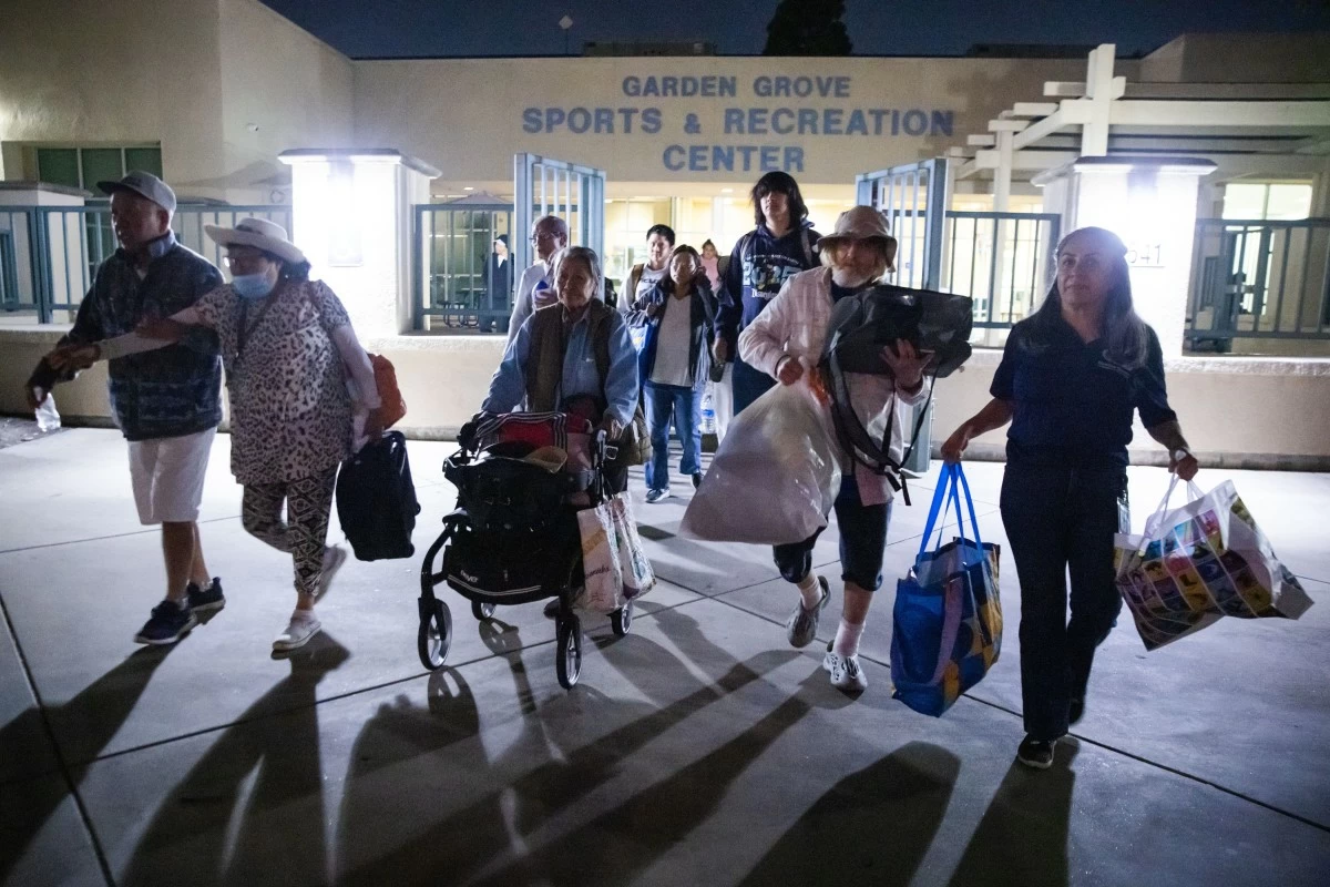 Evacuees from an aerospace chemical plant tank leak move to another shelter after the Garden Grove Sports and Recreation Center closed for the night in Garden Grove, Calif., Friday, May 22, 2026. (AP Photo/Ethan Swope)