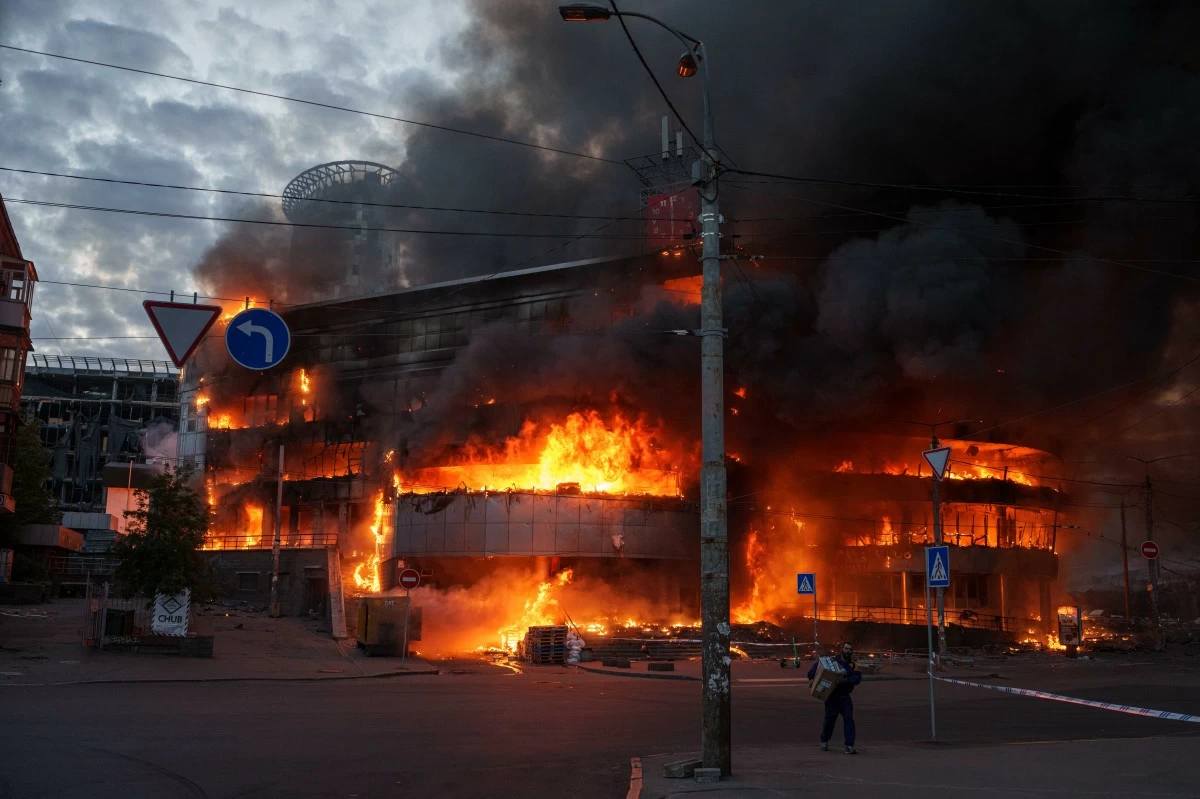 A man carries a box from a burning trade center after a Russian strike on Kyiv, Ukraine, on Sunday, May 24, 2026. (AP Photo/Evgeniy Maloletka)