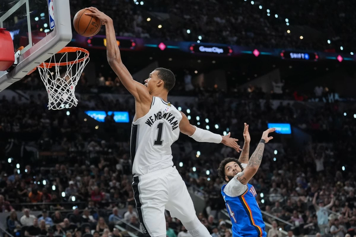 San Antonio Spurs forward Victor Wembanyama (1) scores a basket against Oklahoma City Thunder guard Kenrich Williams during the second half of Game 4 in the Western Conference finals NBA basketball playoffs series in San Antonio, Sunday, May 24, 2026. (AP Photo/Eric Gay)