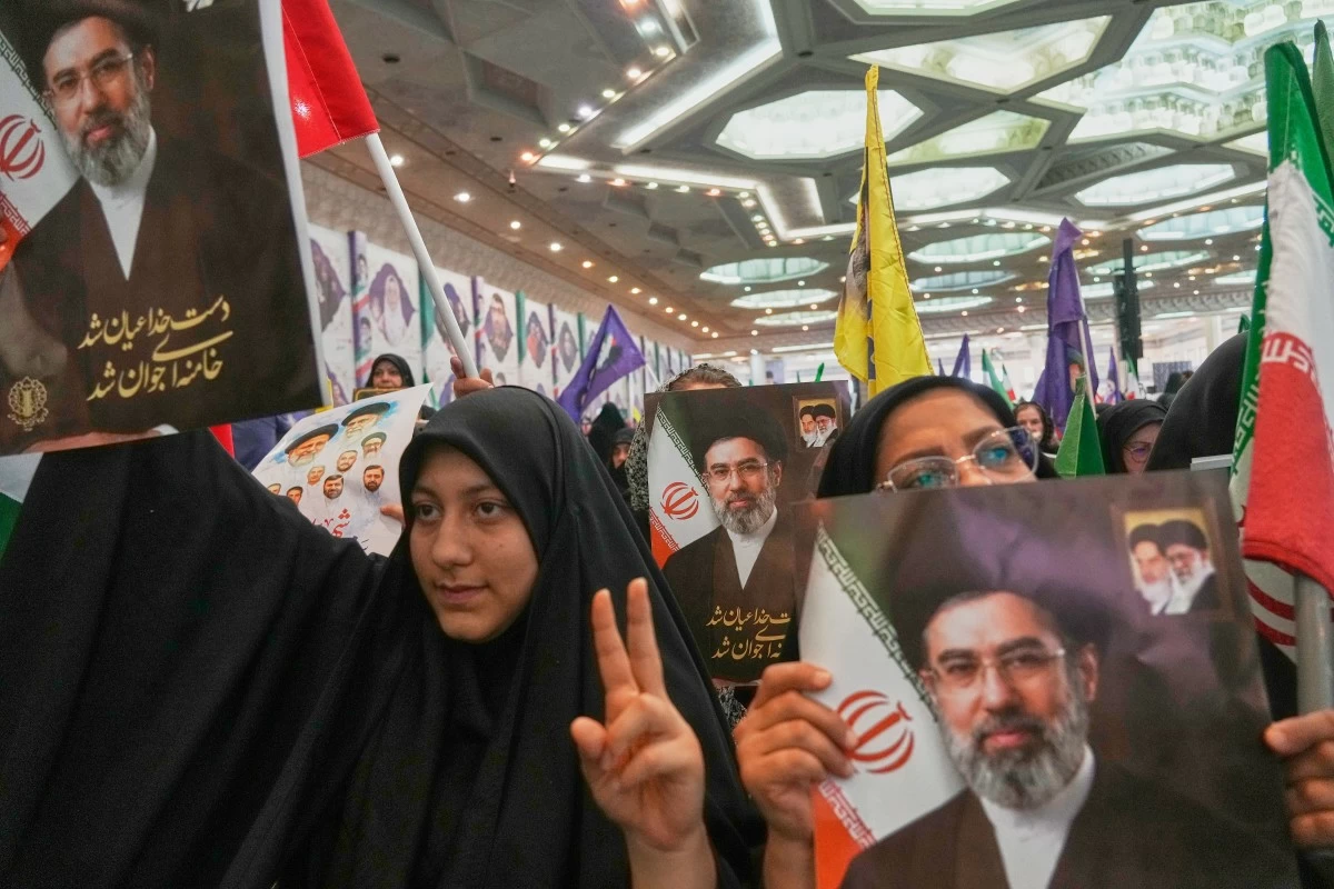 Women hold portraits of Iran's Supreme Leader, Ayatollah Mojtaba Khamenei, during a ceremony honoring the armed forces and those killed in the war with Israel and the U.S. at the Imam Khomeini Grand Mosque in Tehran, Iran, Sunday, May 24, 2026. (AP Photo/Vahid Salemi)