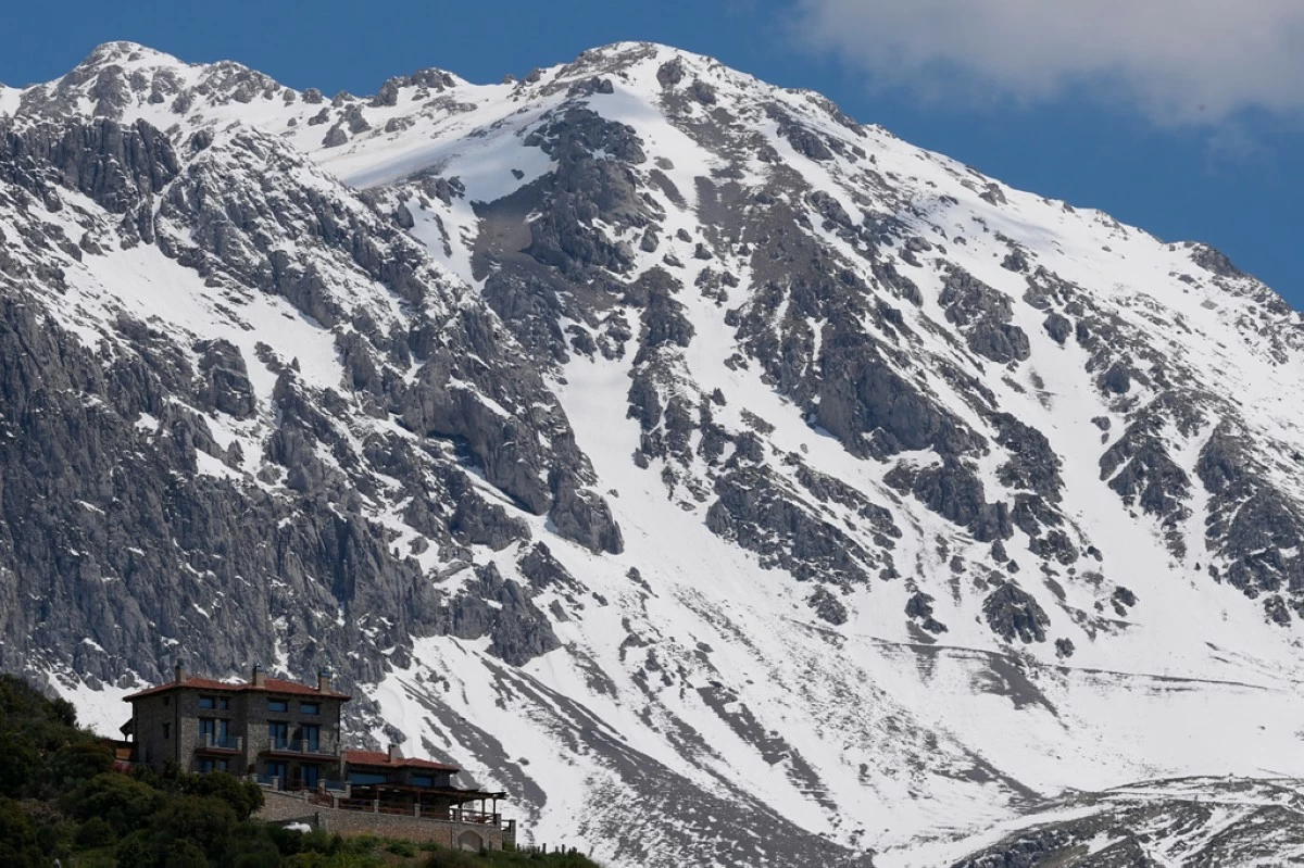 A chalet stands at the foothills of snow-covered Mount Parnassos in the popular winter resort town of Arachova, central Greece, on May 5, 2026. (AP Photo/Thanassis Stavrakis)