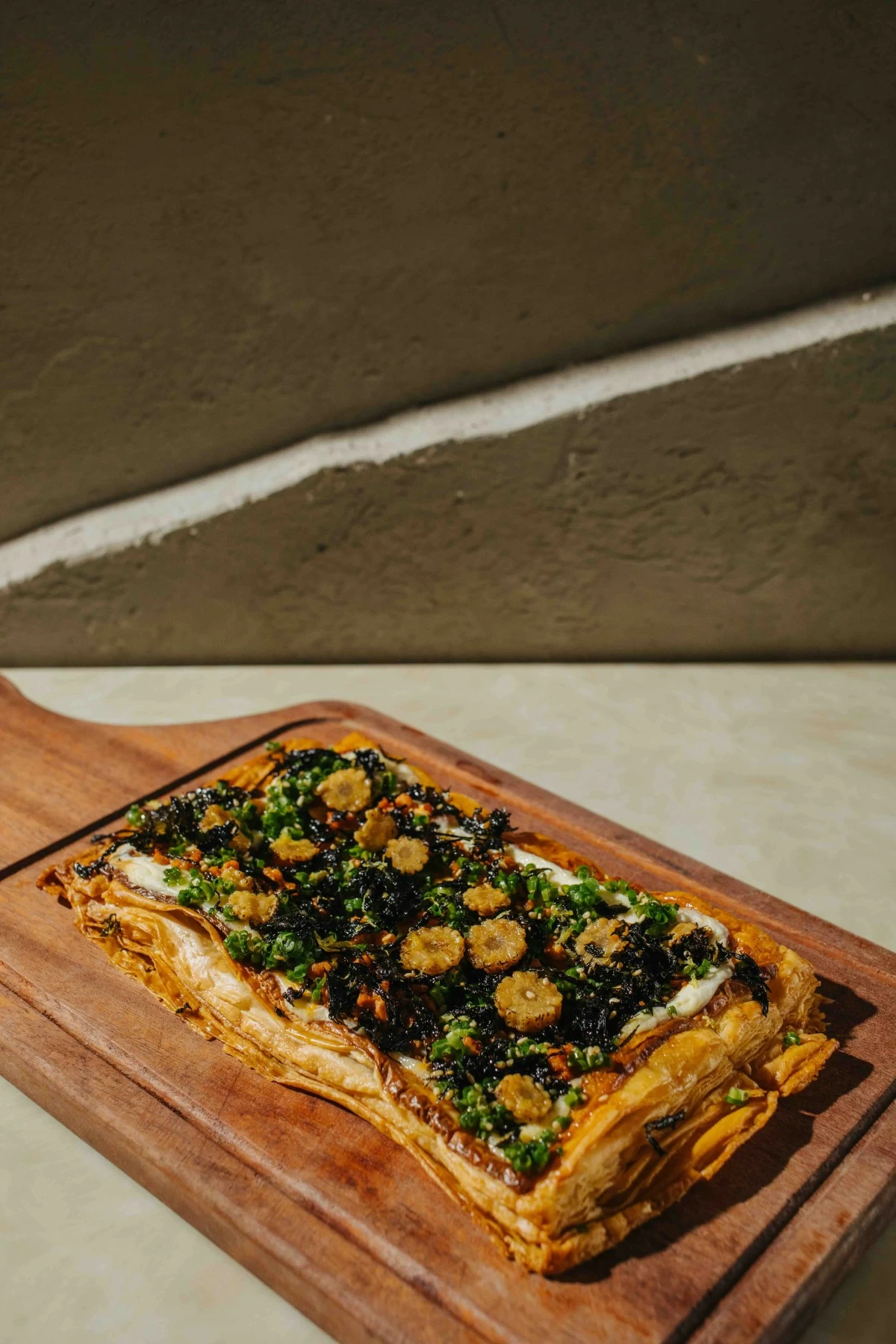 PUFF PIE The Inferno Tantan Puff Pizza combines yuzu cream cheese, tantan sesame pork, crispy nori, and wasabi honey on Half Saints’ signature pastry base (Photo: Arabella Paner)