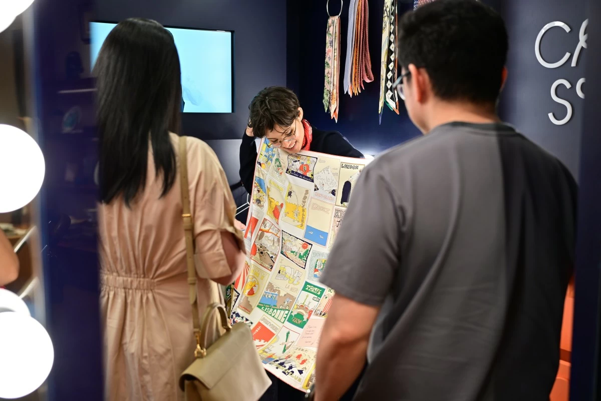 The hostess teaching guests the different ways to style Hermès silk.