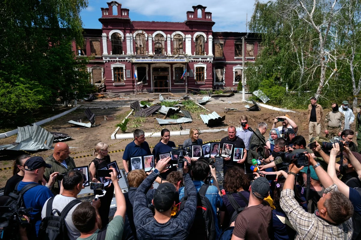 FILE - Russia's Commissioner for Human Rights Yana Lantratova, center right, stands by citizens holding portraits of what they say were victims of a Ukrainian drone strike in Starobilsk in the Russia-controlled Luhansk region of Ukraine, on Sunday, May 24, 2026. (AP Photo/Pavel Bednyakov, File)